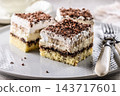 Delicious layered cakes with cream, bananas, and fluffy whipped cream served on an elegant plate. The top of the desserts is sprinkled with finely grated dark chocolate 143717601
