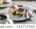 Delicious layered cakes with cream, bananas, and fluffy whipped cream served on an elegant plate. The top of the desserts is sprinkled with finely grated dark chocolate 143717602