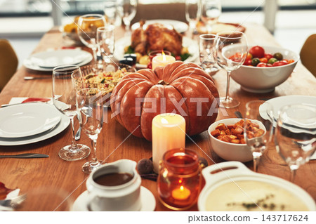 Thanksgiving, food and pumpkin on table in home for dinner party, celebration and family or social event. Cooking and closeup of feast, dish and gourmet meal for holiday, festive eating or lunch Thanksgiving, food and pumpkin on table in home for dinner party, celebration and family or social event. Cooking and closeup of feast, dish and gourmet meal for holiday, festive eating or lunch 143717624