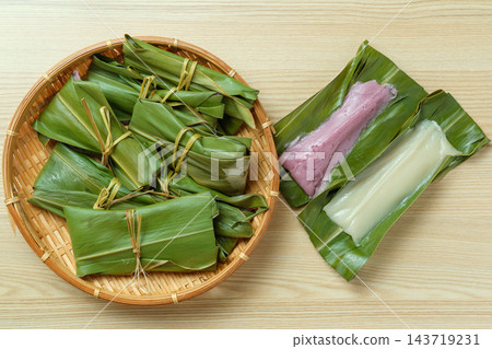 從上方俯瞰一個竹籃和一片展開的白色和紫色麻糬。 從上方俯瞰一個竹籃和一片展開的白色和紫色麻糬。 143719231