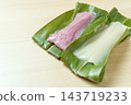 Close-up of white and purple mochi made from opened ginger lily leaves. 143719233