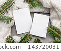 Blank vertical cards mockup near green fir branches and white knitted blanket. Rustic holiday scene 143720031