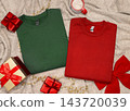 Dark green and red folded sweatshirts mockup near Christmas decor, copy space. Holiday apparel flat lay 143720039