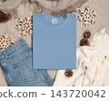 Falded washed light blue t-shirt mockup near rustic Christmas decor, flat lay. Holiday template 143720042