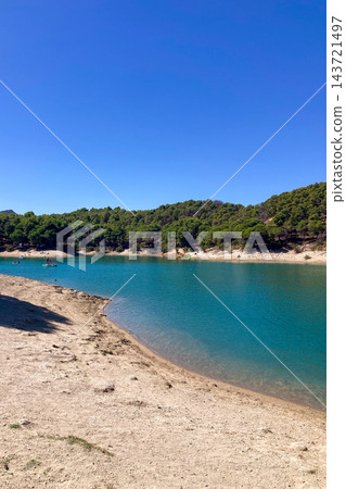 El Chorro Reservoir inland beach surrounded by rugged mountains and dramatic cliffs creates a scenic recreational landscape in Andalusia, Spain 143721497
