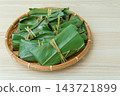 A view of mochi served on a bamboo basket on a wooden surface, from an angle. 143721899