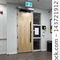 A large, modern wooden door at the entrance of the building. 143721912