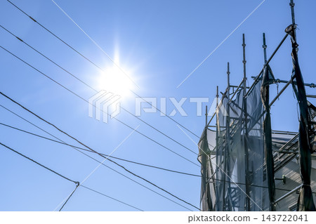 在藍天白雲和陽光下搭建的用於外牆翻新工程的臨時鷹架。 在藍天白雲和陽光下搭建的用於外牆翻新工程的臨時鷹架。 143722041