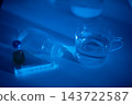 Clinical environment with nurse readying injection supplies at night. Grainy image depicting nurse or paramedic preparing to administer medication during nighttime hours 143722587