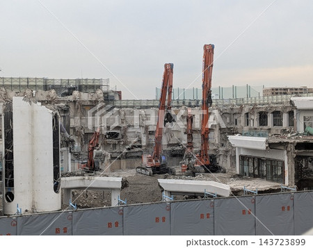 使用重型機械拆除一座歷史悠久的購物中心和建築群。 使用重型機械拆除一座歷史悠久的購物中心和建築群。 143723899