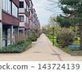 Residential street with trees and pedestrian walkway. 143724139