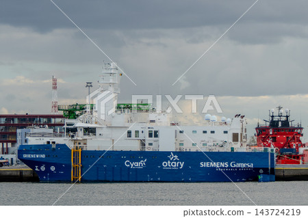 Groenewind offshore wind service operation vessel moored at a harbor pier under a cloudy sky Groenewind offshore wind service operation vessel moored at a harbor pier under a cloudy sky 143724219