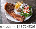 Delicious Grilled Pork Chop Meal with Fries and Salad 143724526