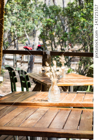 A restaurant surrounded by trees, with wooden tables set up under a large tent roof, on the island of Corsica in the Mediterranean Sea. A restaurant surrounded by trees, with wooden tables set up under a large tent roof, on the island of Corsica in the Mediterranean Sea. 143725317
