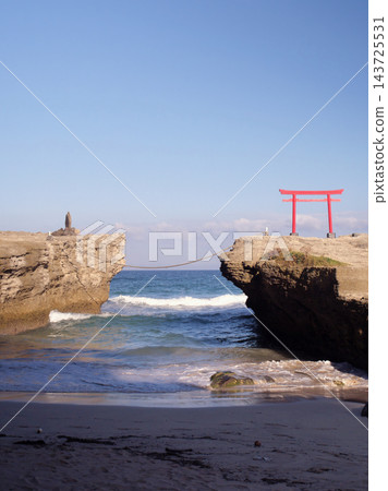 在靜岡縣下田市白濱海灘的岩石海岸上，矗立著一座朱紅色的鳥居，以蔚藍的大海為背景。 143725531