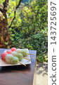 Delicious-looking three-colored dango against a green background 143725697