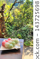 Delicious-looking three-colored dango against a green background 143725698