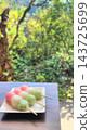 Delicious-looking three-colored dango against a green background 143725699