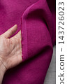 Hand Holding Raw Edge Fuchsia Pink Linen Fabric 143726023