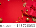 Red Christmas background flat lay: red gift box with satin bow, gold baubles, gold glitter snowflakes and serpentine ribbon, large copy space on the left for text, greeting card, invitation 143726033
