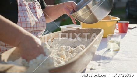 Woman baking bread kneading dough with flour 143726359