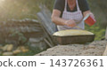 Woman preparing homemade bread dough outdoors at sunset 143726361