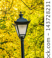 Vintage Street Lamp in Autumn Park With Yellow Leaves Bokeh Background and Warm Fall Light 143728231