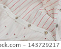 White fabric texture in cherry and flowers. Macro of a newborn photo suit. 143729217
