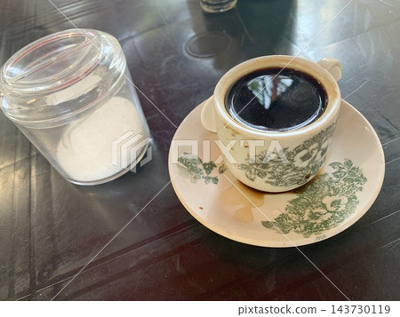 一個老式馬來西亞咖啡杯裡裝著黑咖啡和糖。 143730119