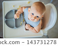 Infant developing food handling skills with cauliflower florets. 143731278