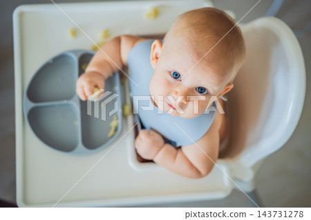 Infant developing food handling skills with cauliflower florets. Infant developing food handling skills with cauliflower florets. 143731278