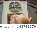 Infant trying cauliflower florets during a complementary feeding meal. 143731279