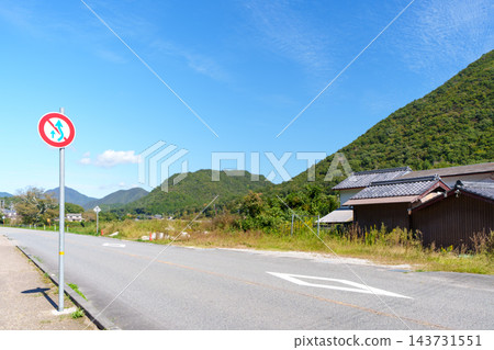 秋高氣爽的天空,山腳下公路旁的交通標誌,以及鄉村風景。 秋高氣爽的天空,山腳下公路旁的交通標誌,以及鄉村風景。 143731551
