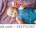 Baby learning through touch and mouth exploration of a rattle. 143731567