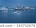 A sightseeing boat sailing through Yokohama Port at dusk and a Japan Coast Guard patrol vessel docked at the pier. A sightseeing boat sailing through Yokohama Port at dusk and a Japan Coast Guard patrol vessel docked at the pier. 143732678