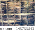 Weathered wooden boards with metal wires stretched across them and a rustic texture 143733843