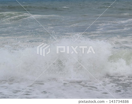白色海浪拍打著沙灘，激起陣陣白色浪花。 143734886