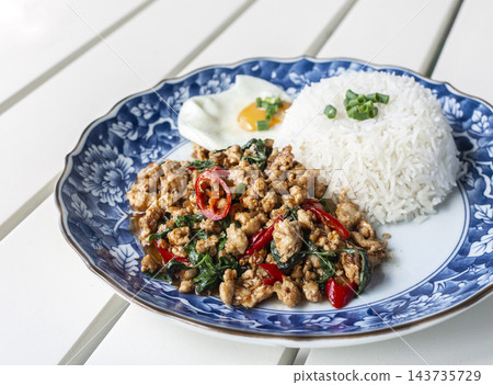pad kaprow gai spicy chicken and basil stir-fry Thai food meal on modern phuket restaurant table pad kaprow gai spicy chicken and basil stir-fry Thai food meal on modern phuket restaurant table 143735729