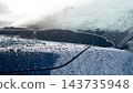 Close up of a car windshield during heavy rain with wiper blades. Operating and water droplets splashing across the glass surface. 143735948