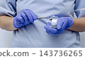Dentist presenting metal tooth crowns in a small container as part of dental restoration preparation 143736265