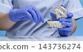 Dentist Demonstrating Dental Flossing Technique Around Dental Implants Using Interdental Floss Pick and Transparent Jaw Model 143736274