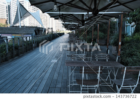 A sophisticated open-air cafe with terrace seating overlooking the expansive waterfront. A sophisticated open-air cafe with terrace seating overlooking the expansive waterfront. 143736722