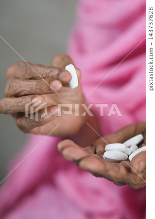 elderly woman hands holding white tablets during medication elderly woman hands holding white tablets during medication 143737628