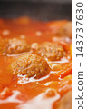 Meatballs simmer in tomato sauce during cooking on a stove 143737630