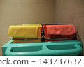 Colorful towels draped over storage bins on a turquoise shelf 143737632