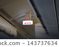 Emergency exit sign above the aisle inside an aircraft cabin 143737634
