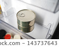 Metal food can with pull tab stored in a refrigerator door shelf 143737643