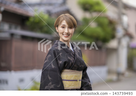 一位五十多歲的女性身穿越後夏季和服,微笑著直視鏡頭,她的肖像照。 一位五十多歲的女性身穿越後夏季和服,微笑著直視鏡頭,她的肖像照。 143739493