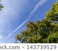 A clear autumn sky and the trees on the mountains beginning to change color. 143739529