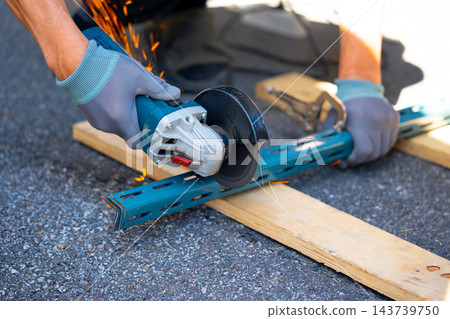Worker cutting metal with many sharp sparks using equipments to cut iron Worker cutting metal with many sharp sparks using equipments to cut iron 143739750